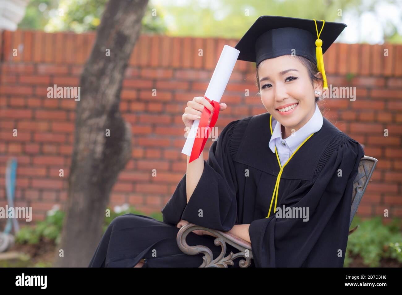 Happy graduated student girl hold certificate - congratulations of education success. Stock Photo
