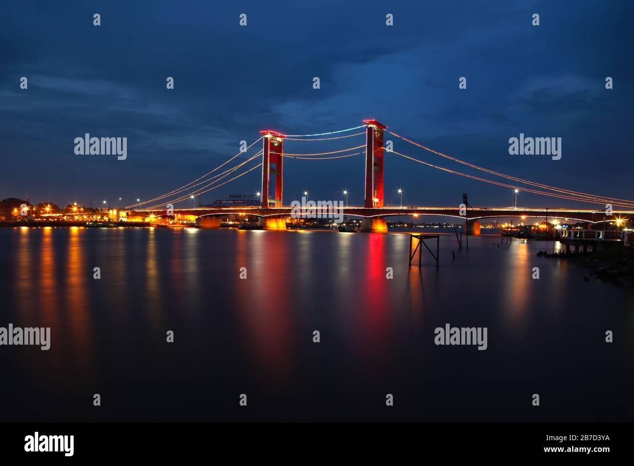 Twilight view of Musi river and the historic Ampera Bridge connecting two parts of Palembang City, South Sumatra, Indonesia. Stock Photo