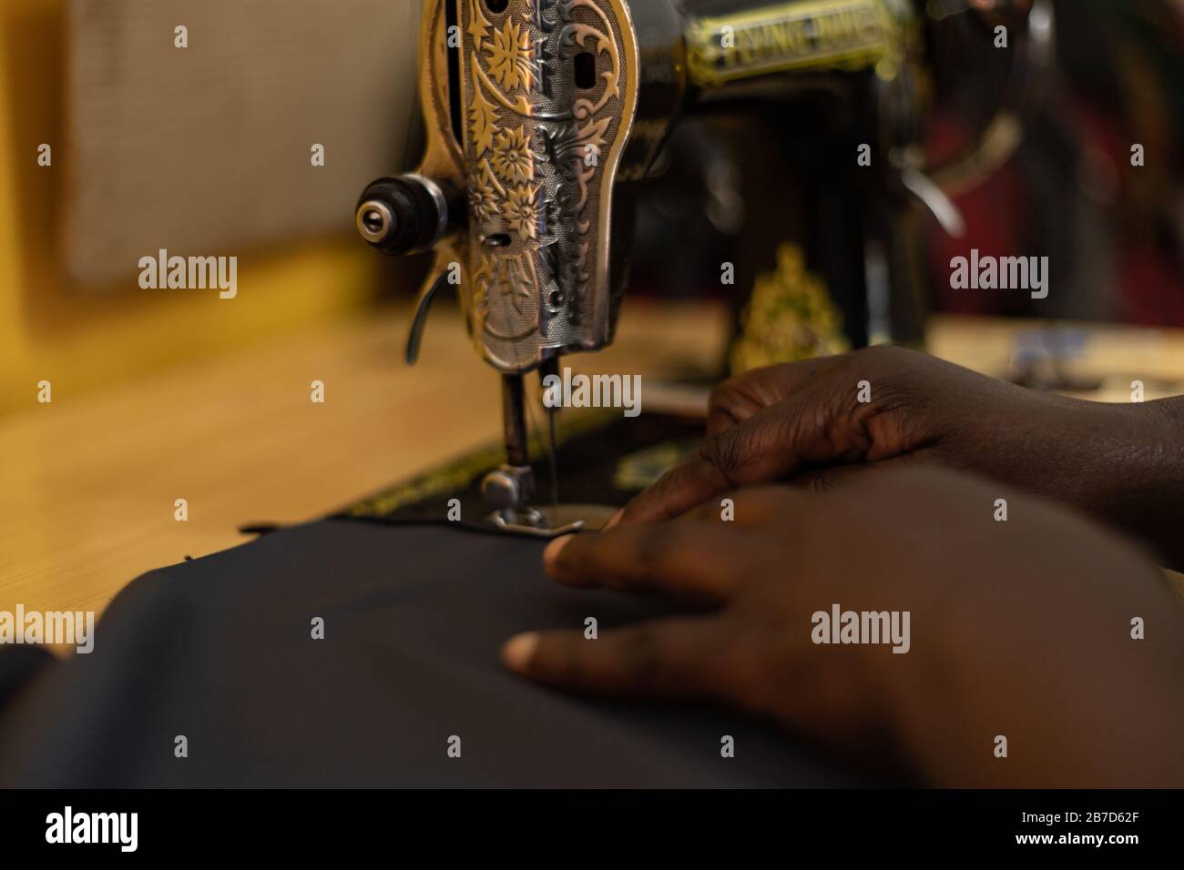 Close up view of African woman sewing garments in Kenya. Lady working