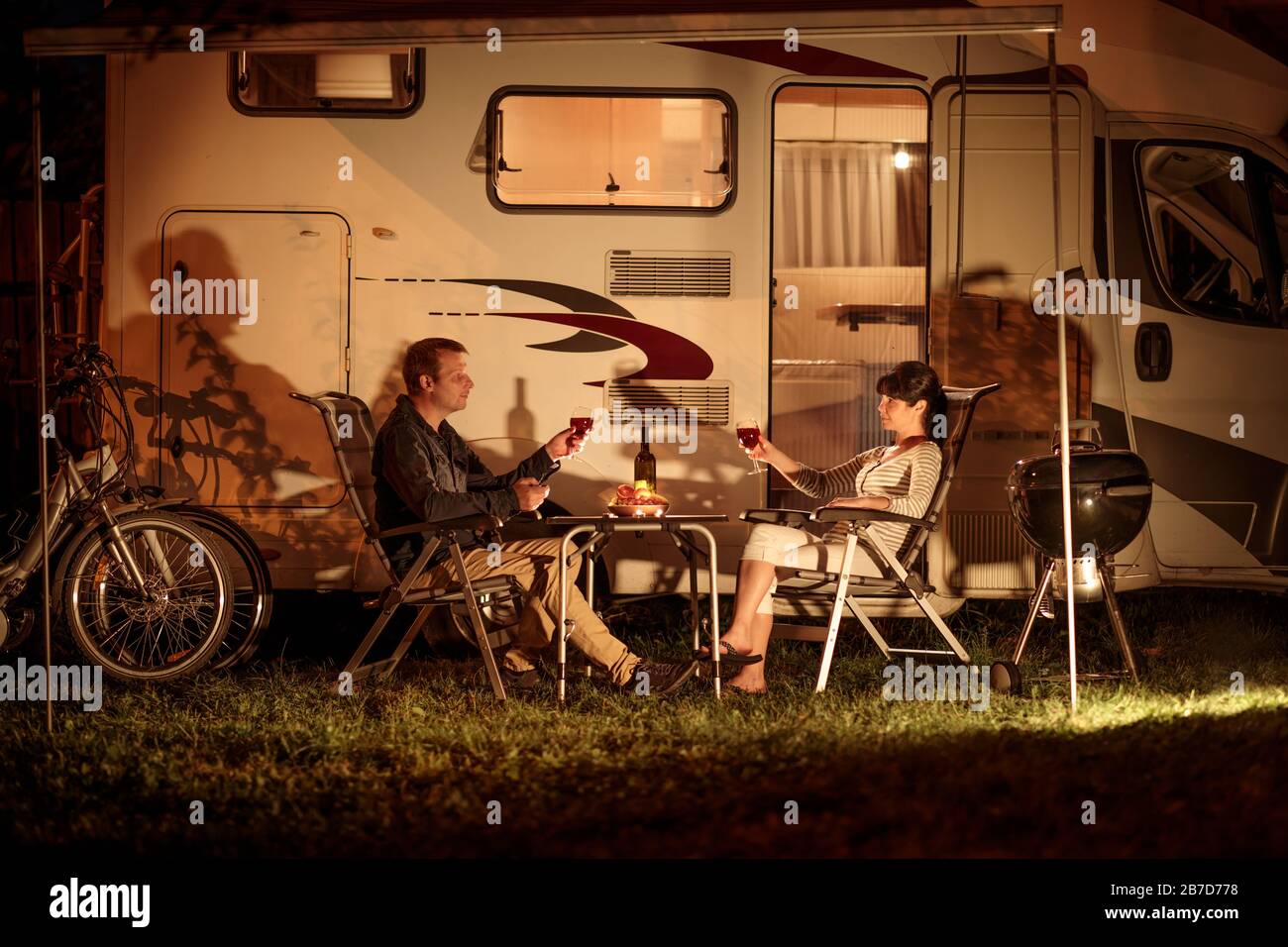 Adult couple clinking glasses of wine. Family vacation travel RV