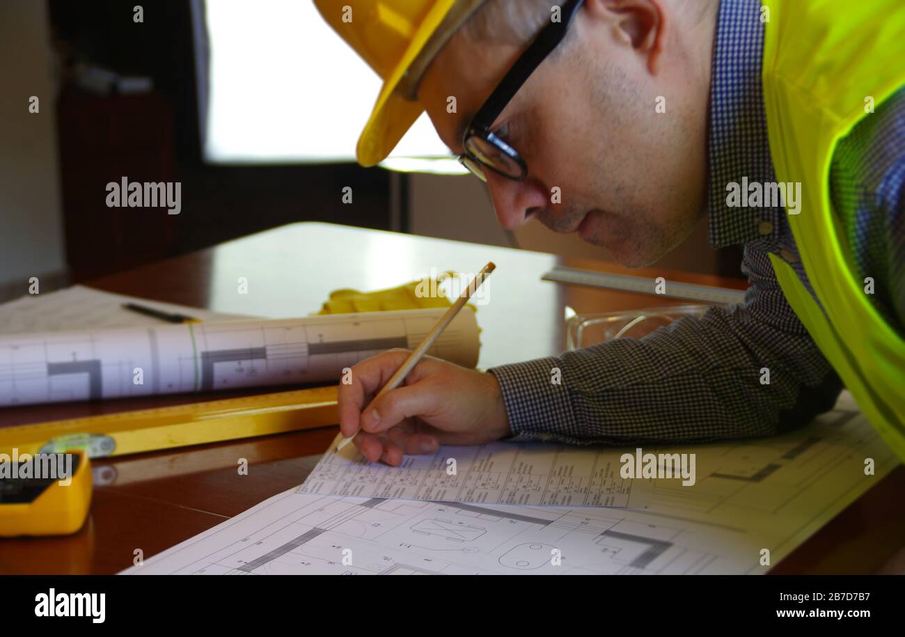 Construction manager, contractor, builder or engineer in workplace. Working man over building sketch. Architecture, engineering and industry concept. Stock Photo