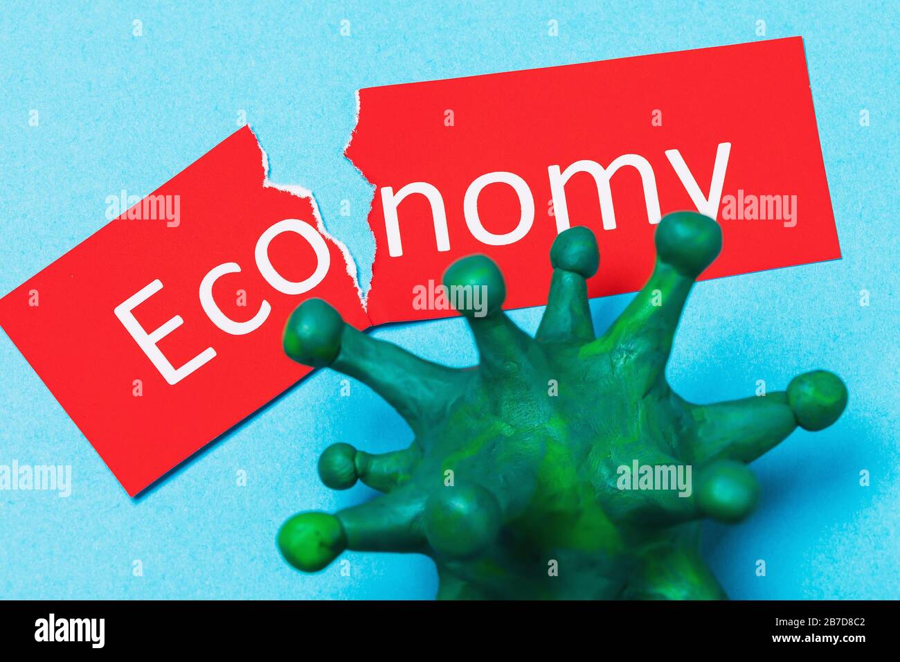 Torn tag with text and coronavirus. The concept of the impact of COVID-19 on the economy Stock Photo