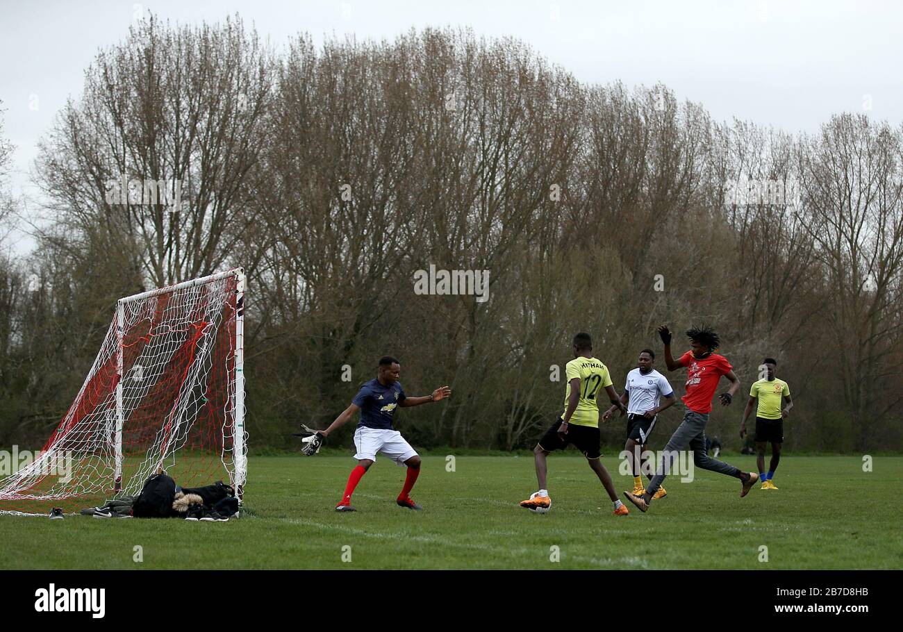 People play football on Hackney Marshes in London following Friday's announcement that the Premier League has suspended all matches until Saturday April 4, 2020. Stock Photo