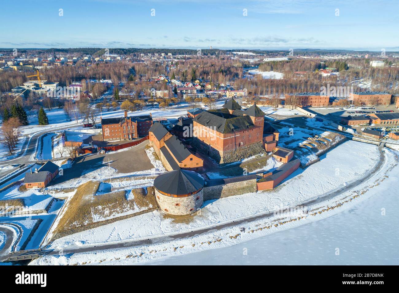 The ancient fortress of the Hameenlinna city against the backdrop of the cityscape on a sunny March day (aerial photography). Finland Stock Photo