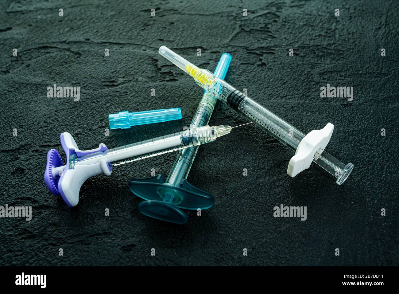 cosmetology injections. Plastic syringe on black background. Medical