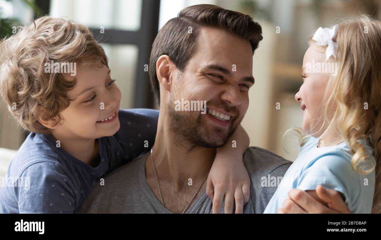 Overjoyed young dad have fun with little kids Stock Photo