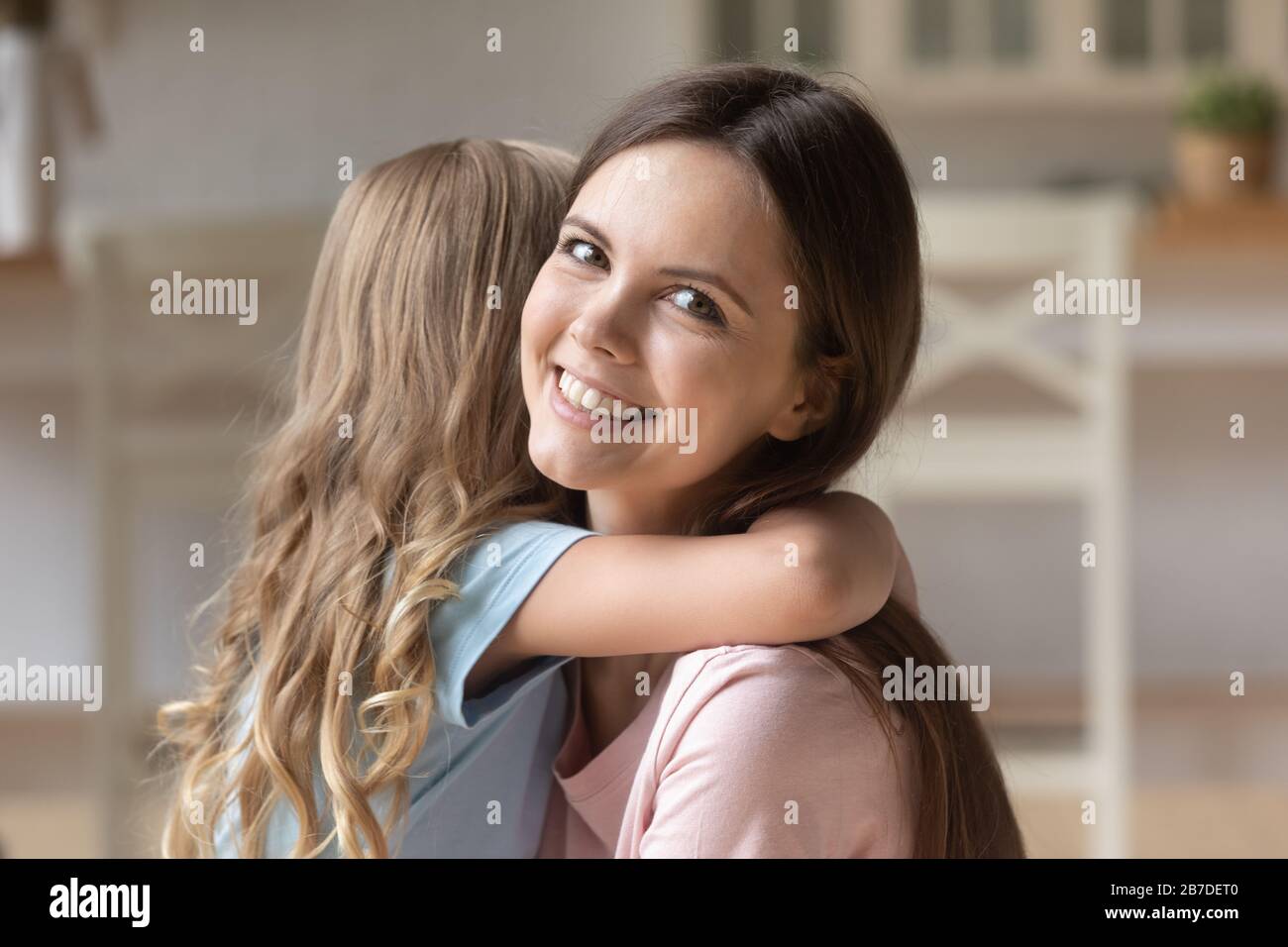 Portrait of smiling mom and little daughter hugging Stock Photo