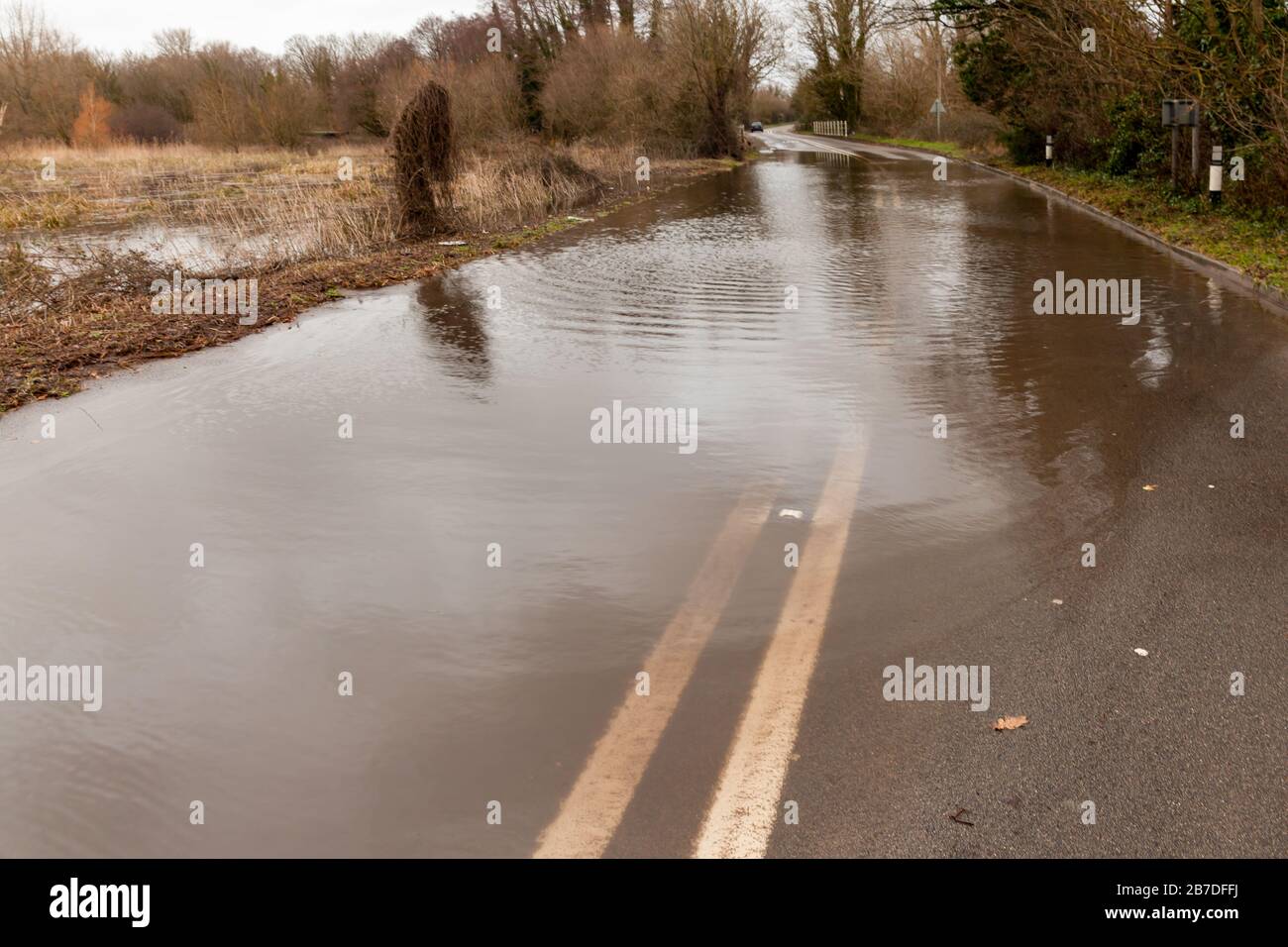 Rural road completely flooded with storm water and double yellow lines Stock Photo