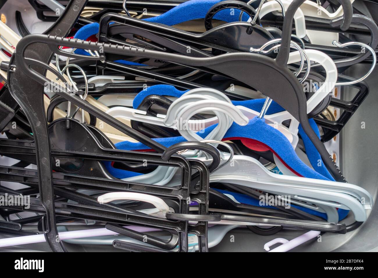 A messy, untidy pile of plastic coat hangers Stock Photo