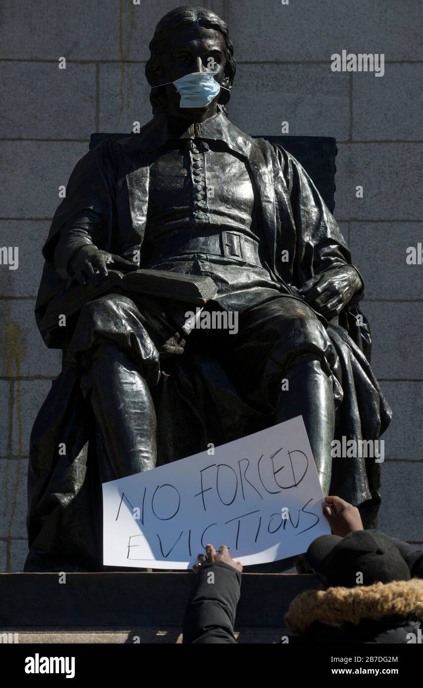 Massachusetts, USA. 14th Mar, 2020. Sculpture of Harvard University founder John Harvard in the Harvard Yard, center of Harvard campus, Harvard’s face has been covered with a face mask. In reaction to Coronavirus concerns Harvard University announced that beginning March 23rd 2020 all classes will be remote or online.  Students living in university residence halls have been asked to leave before March 22 2020. After complaints by students Harvard is making accommodations for students unable to return to their home. Credit: Chuck Nacke/Alamy Live News Stock Photo