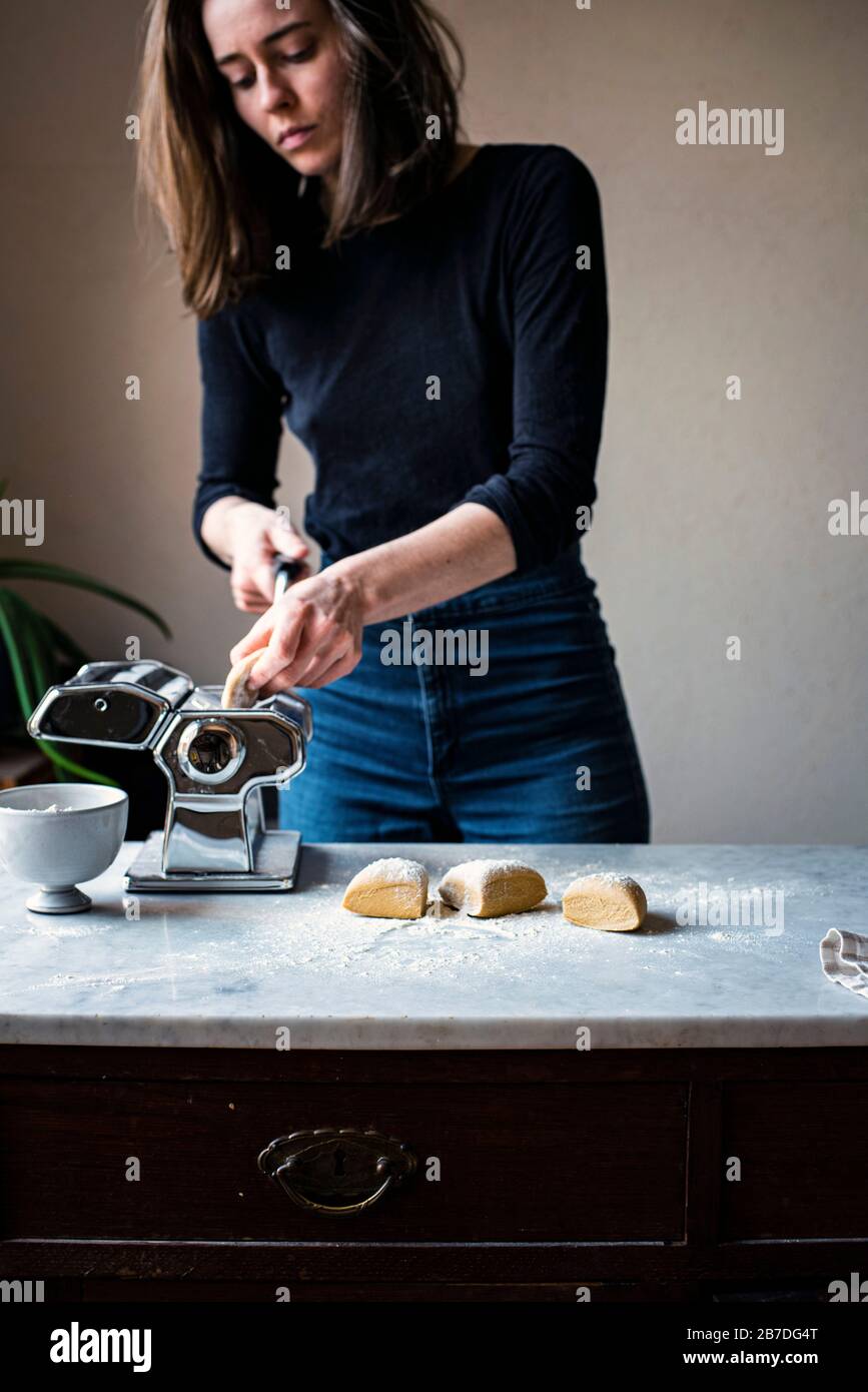 Woman Making Fresh Pasta in a kitchen Stock Photo