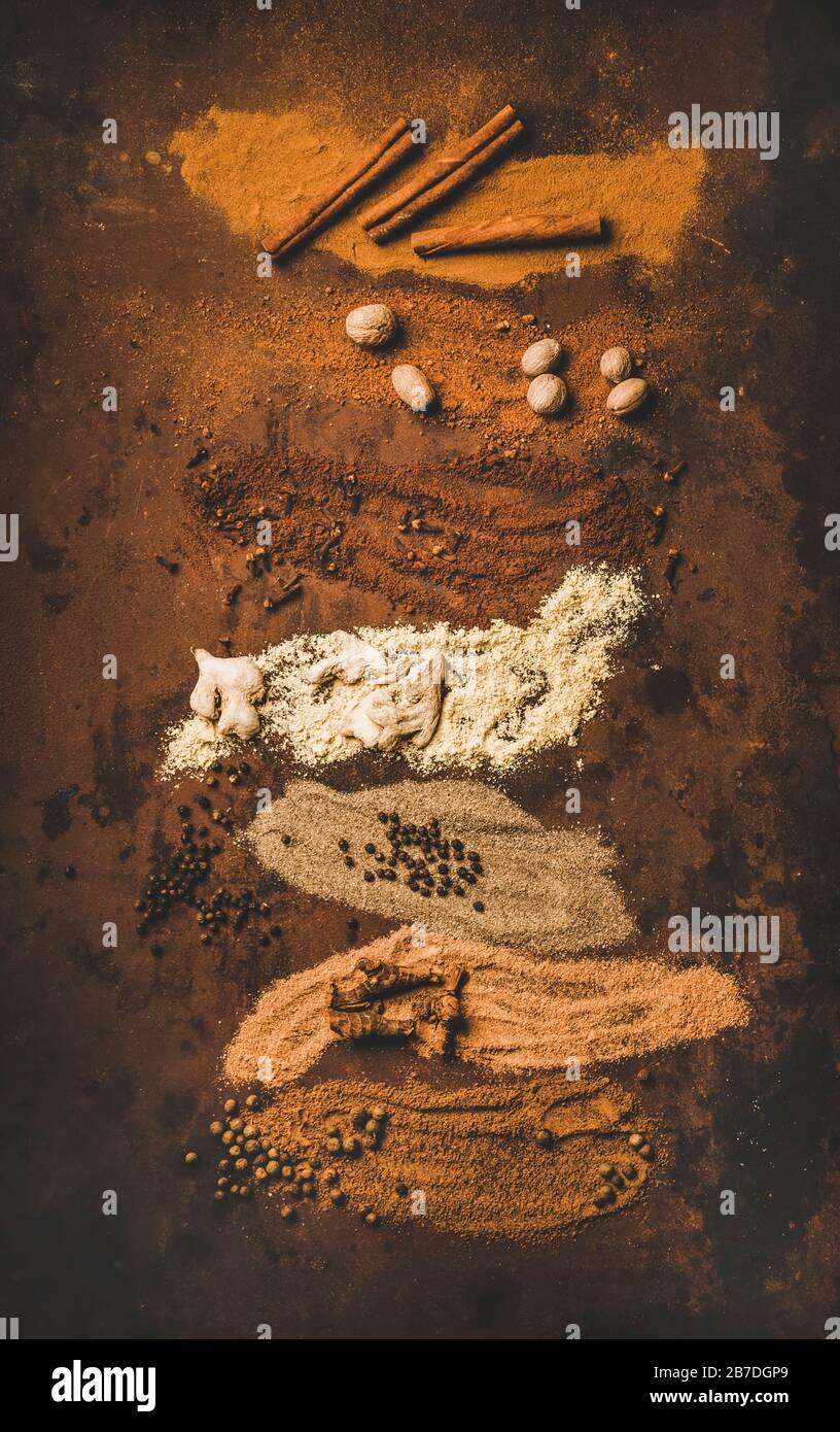 Turkish traditional seven spice Yedi Bahar mix for cooking. Flat-lay of black pepper, ginger, cloves, nutmeg, cinnamon, allspice and alpinia root over Stock Photo