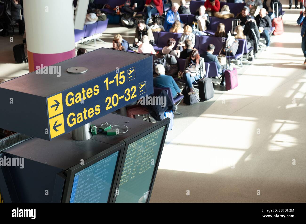 Airport waiting area in departures, passengers waiting, sign to departure gates Stock Photo