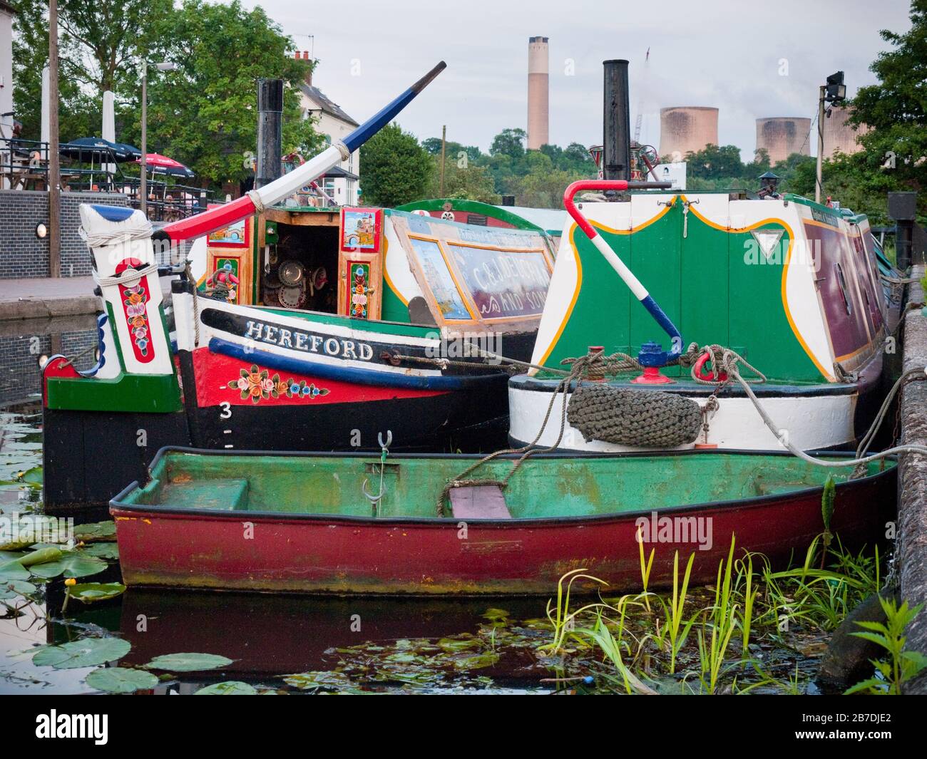 Brightly Painted Historic Narrowboats, Motor and Butty moored with a dinghy on the Erewash Canal, near Trent Falls with Ratcliffe Power Station, Engla Stock Photo