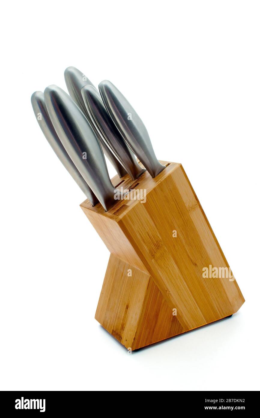 Stainless steel knives in a light wood block on an isolated white background Stock Photo