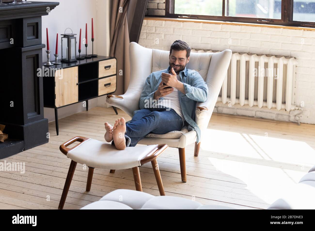 Young man sitting in armchair hi-res stock photography and images - Alamy