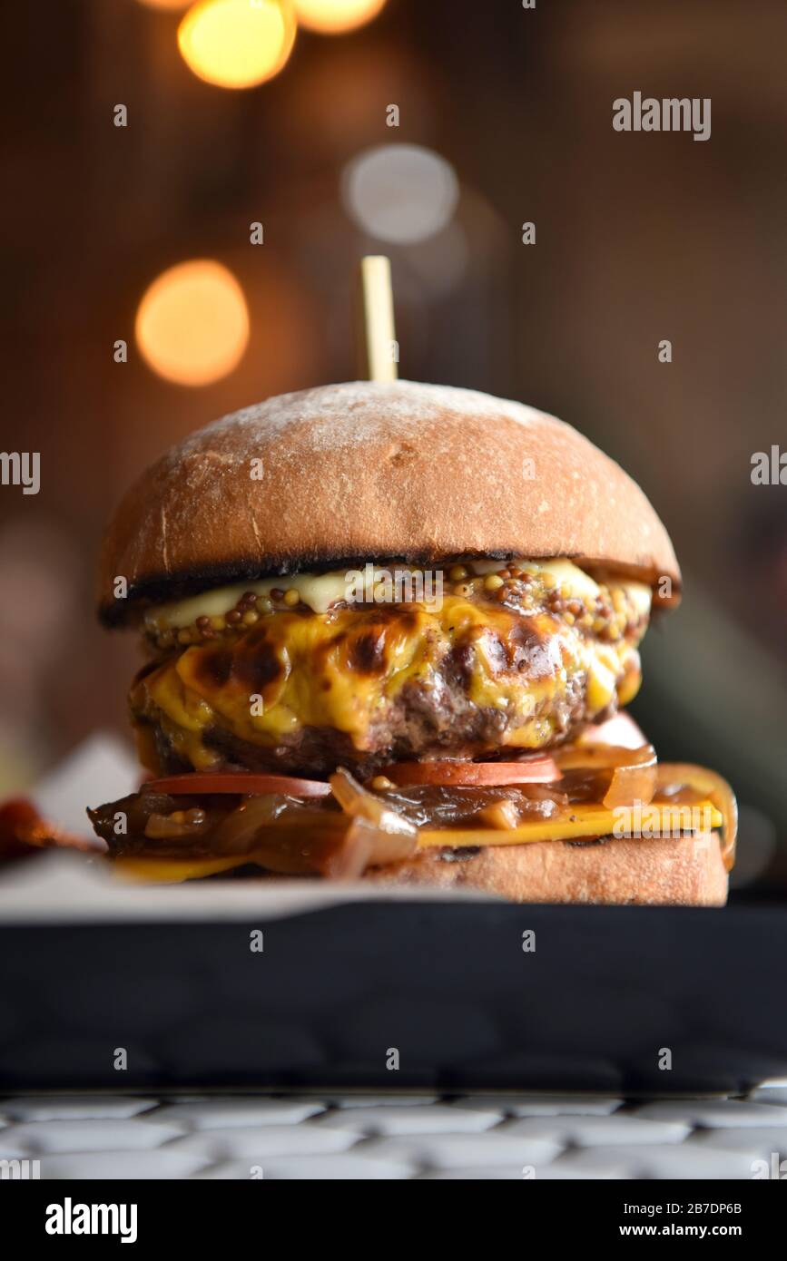 A burger on a plate, stacked in a burger bun Stock Photo