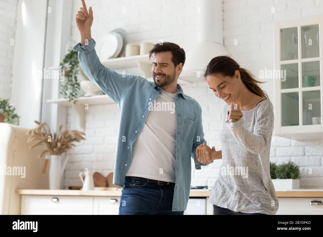 Happy loving couple dancing in modern kitchen together Stock Photo