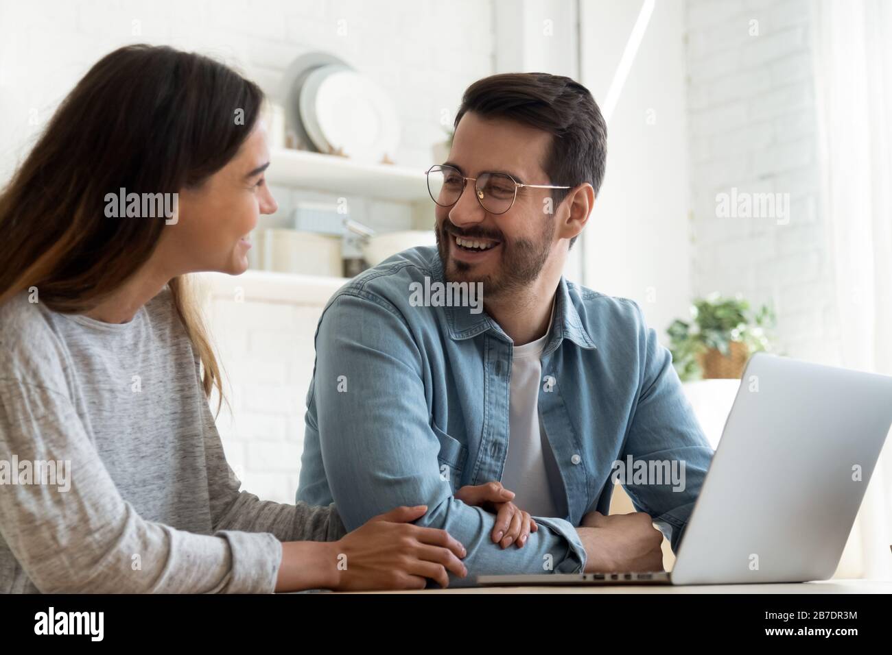 Happy loving couple using laptop together, having fun Stock Photo