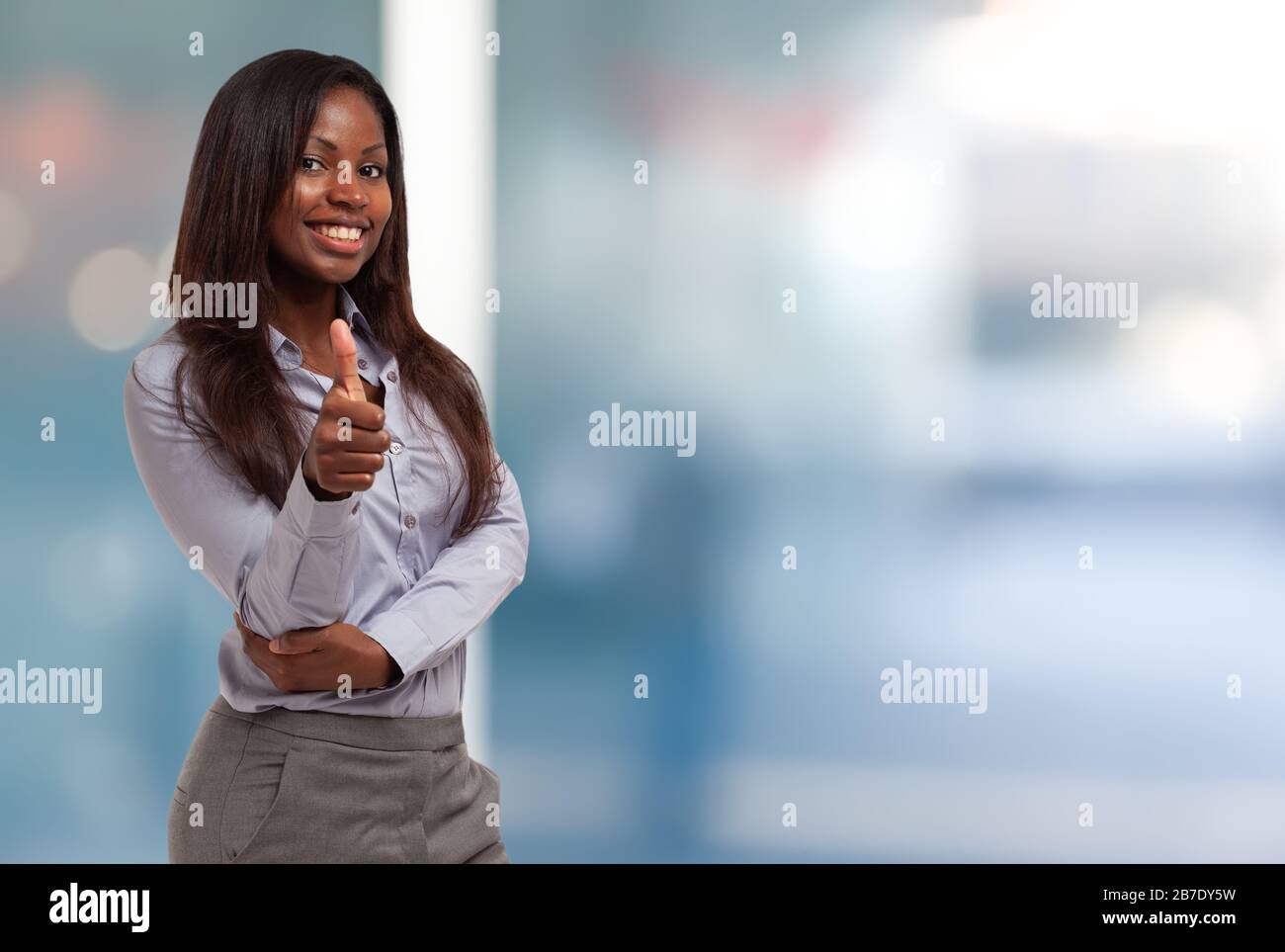 Smiling young black business woman giving thumbs up Stock Photo - Alamy
