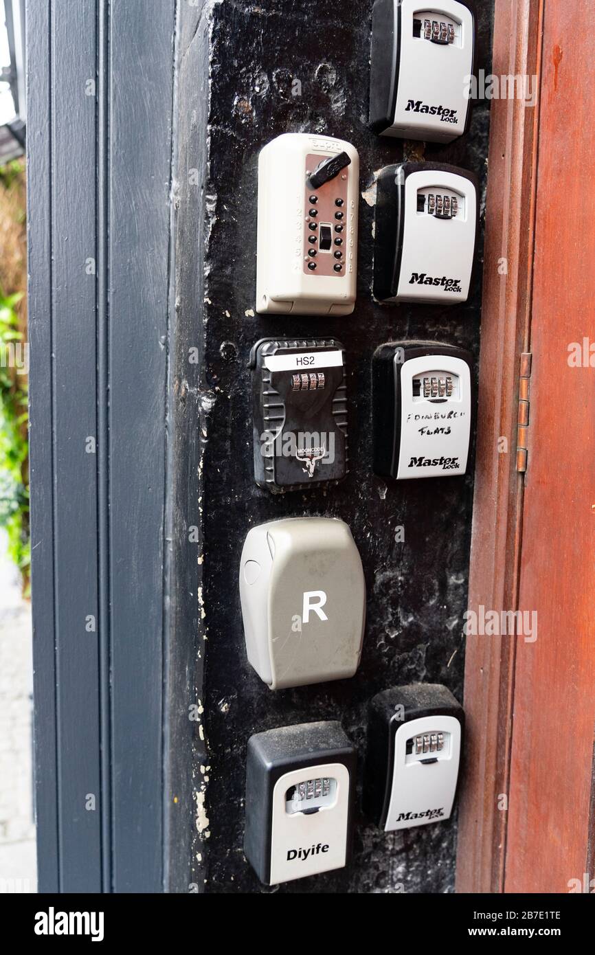 Many key safes used for AirbnB type short-term letting beside apartment building door on Royal Mile in Edinburgh Old Town, Scotland, UK Stock Photo