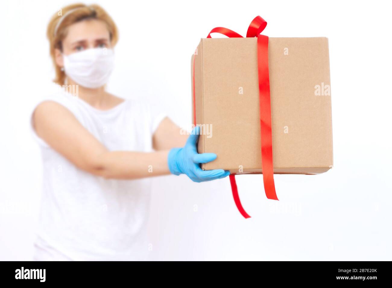 Delivery by courier in rubber gloves and medical mask. The shipping time during coronavirus. Delivery man holding cardboard boxes. copy space.  Stock Photo