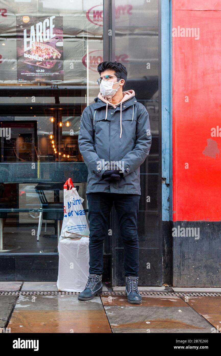 Coventry, West Midlands, UK. 15th Mar, 2020. A shopper stands outside a retail outlet in Coventry wearing a face mask. This comes as the Coronavirus death toll in the UK has risen to 35 after 14 people died from the Covid-19 strain today. Credit: Andy Gibson/Alamy Live News Stock Photo