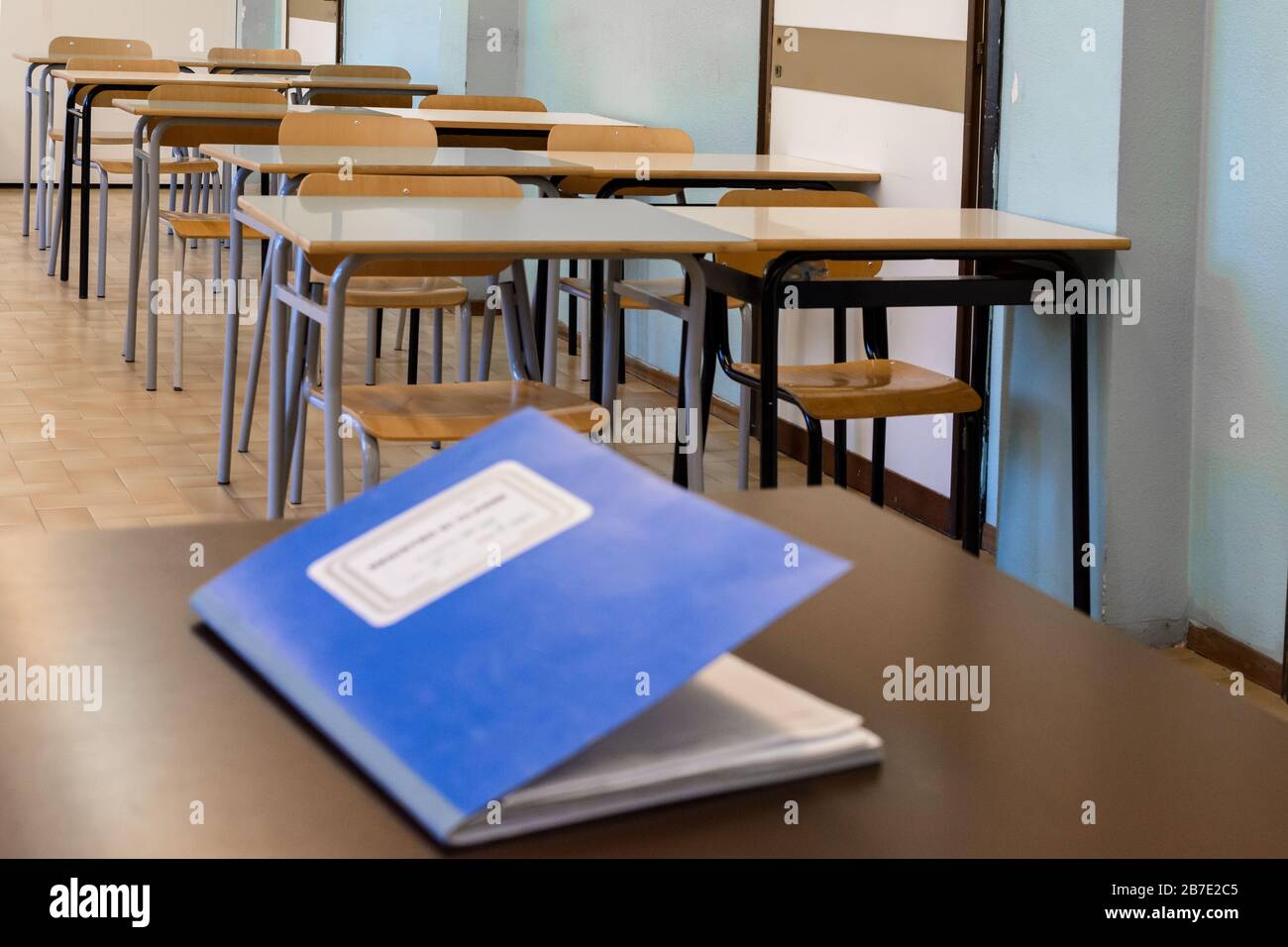 class register closed on the desk, inside a class of a high school, in the background the students' desks.  Translation: 'class register' Stock Photo