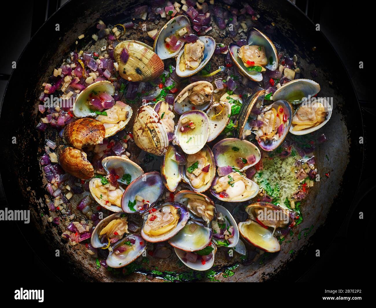 Clams cooking in apan with butter, chopped onions and garlic Stock