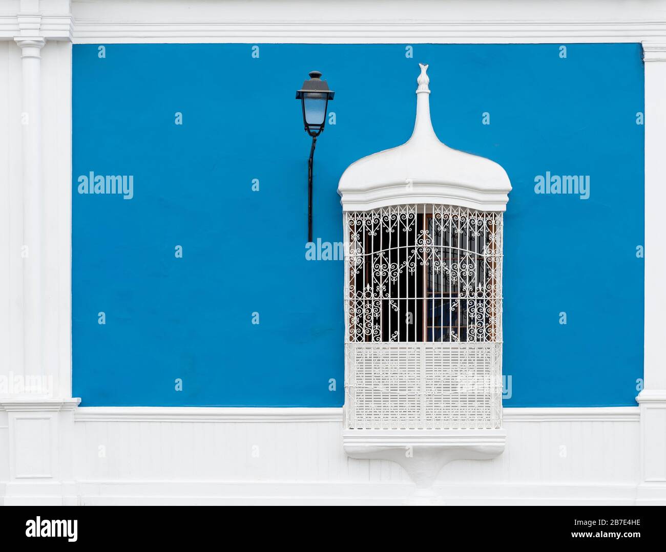 Blue colonial style facade with wrought or cast iron window and lamp post, Trujillo, Peru. Stock Photo