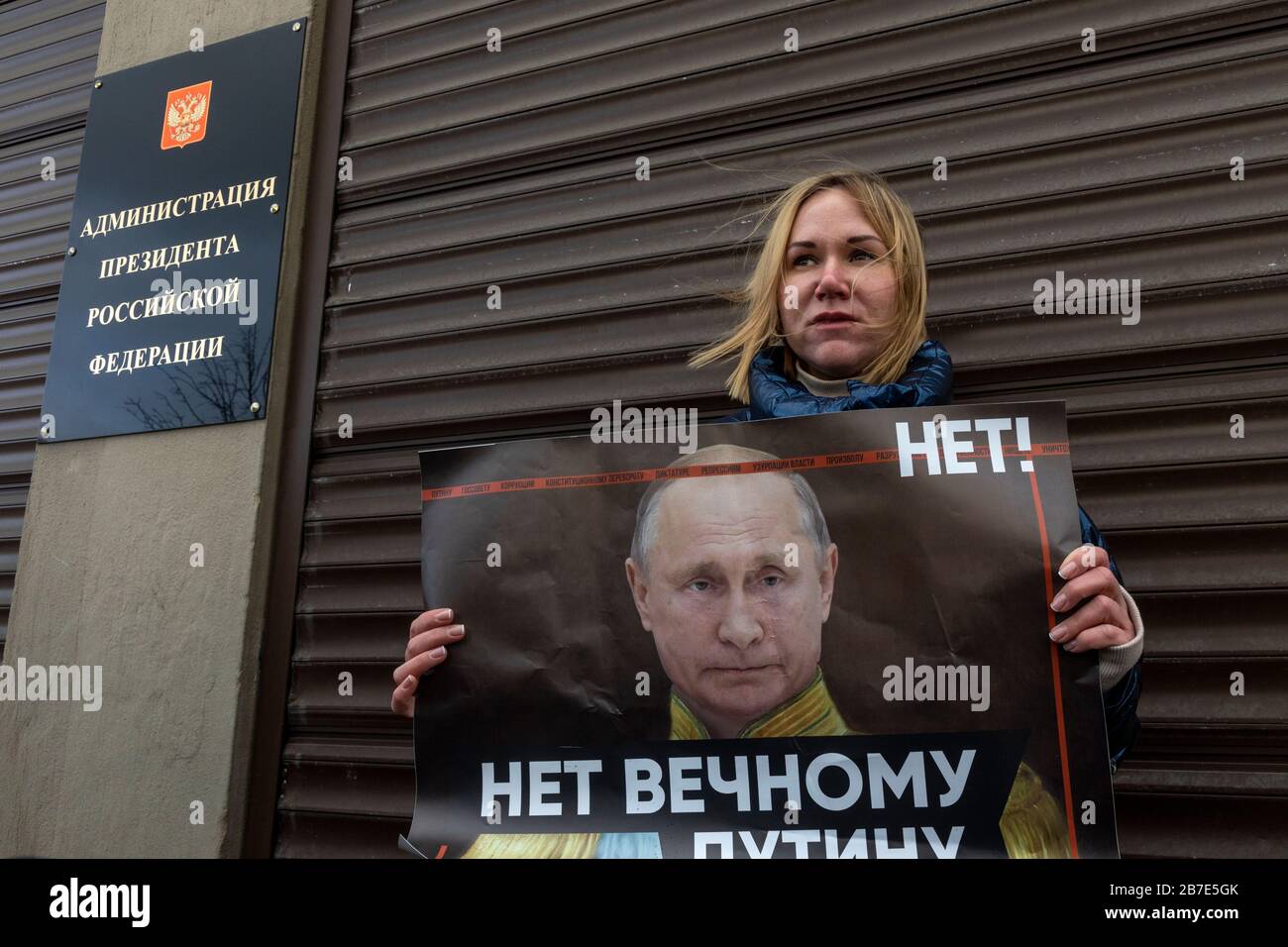 Moscow, Russia. 15th of March, 2020 A woman holds a banner with a message reading 'No to the eternal Putin' during a single protest against the proposed constitutional amendments near the building of the Presidential Executive Office at Staraya Ploshchad Street in central Moscow. On 11 March 2020, Russia's State Duma backed a batch of proposed amendments to the Russian constitution. One of the amendments would make it possible for presidents of Russia to be re-elected regardless of the existing constitutional rule which limits the number of consecutive presidential terms Stock Photo