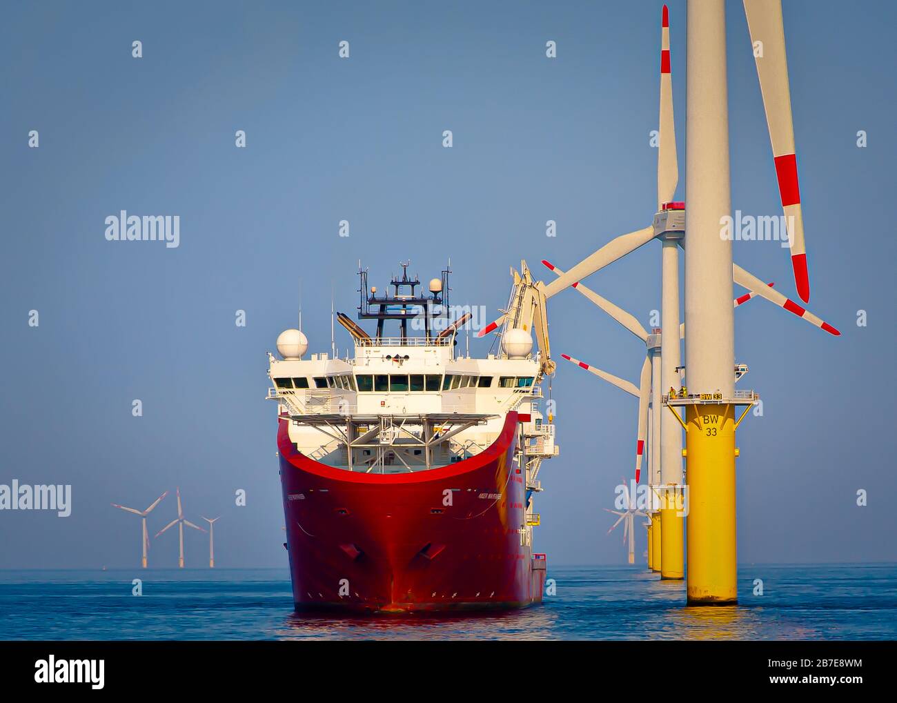 Offshore support vessel holding station with dynamic positioning, whilst carrying out operations on offshore wind turbine asset Stock Photo
