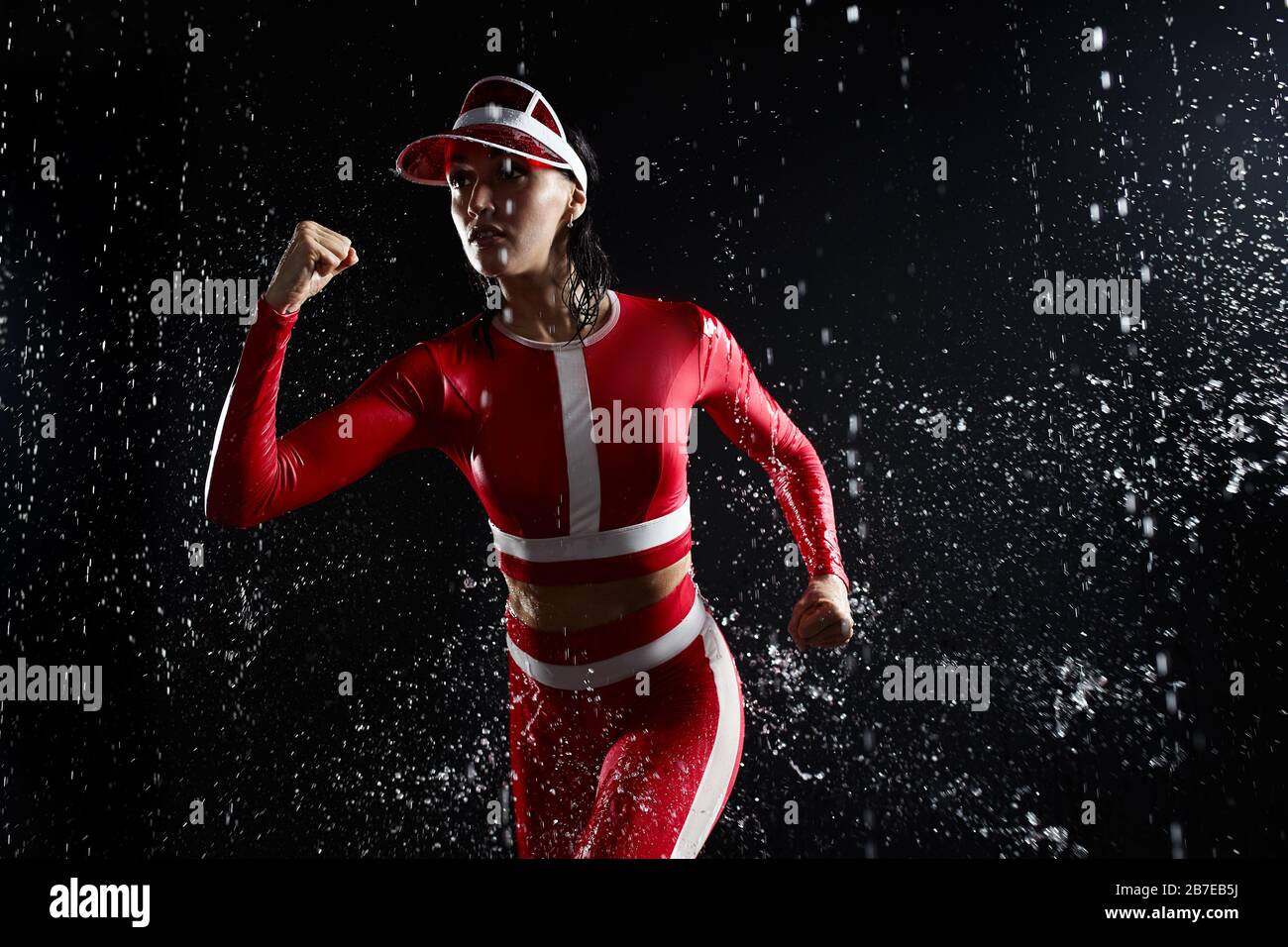 Beautiful young girl in sportswear in aqua studio. Drops of water