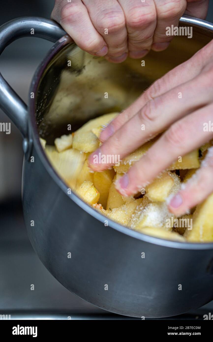 Peeling apples for apple pie hand visible. Stock Photo