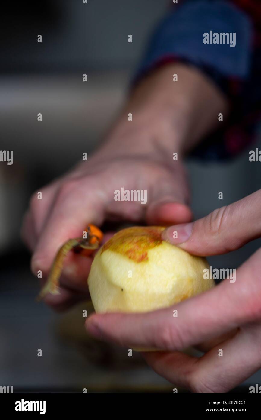 Peeling apples for apple pie hand visible. Stock Photo