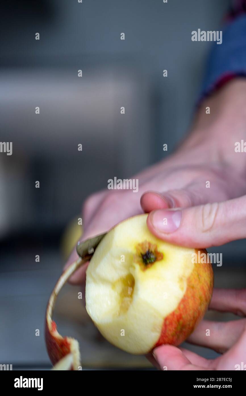 Peeling apples for apple pie hand visible. Stock Photo