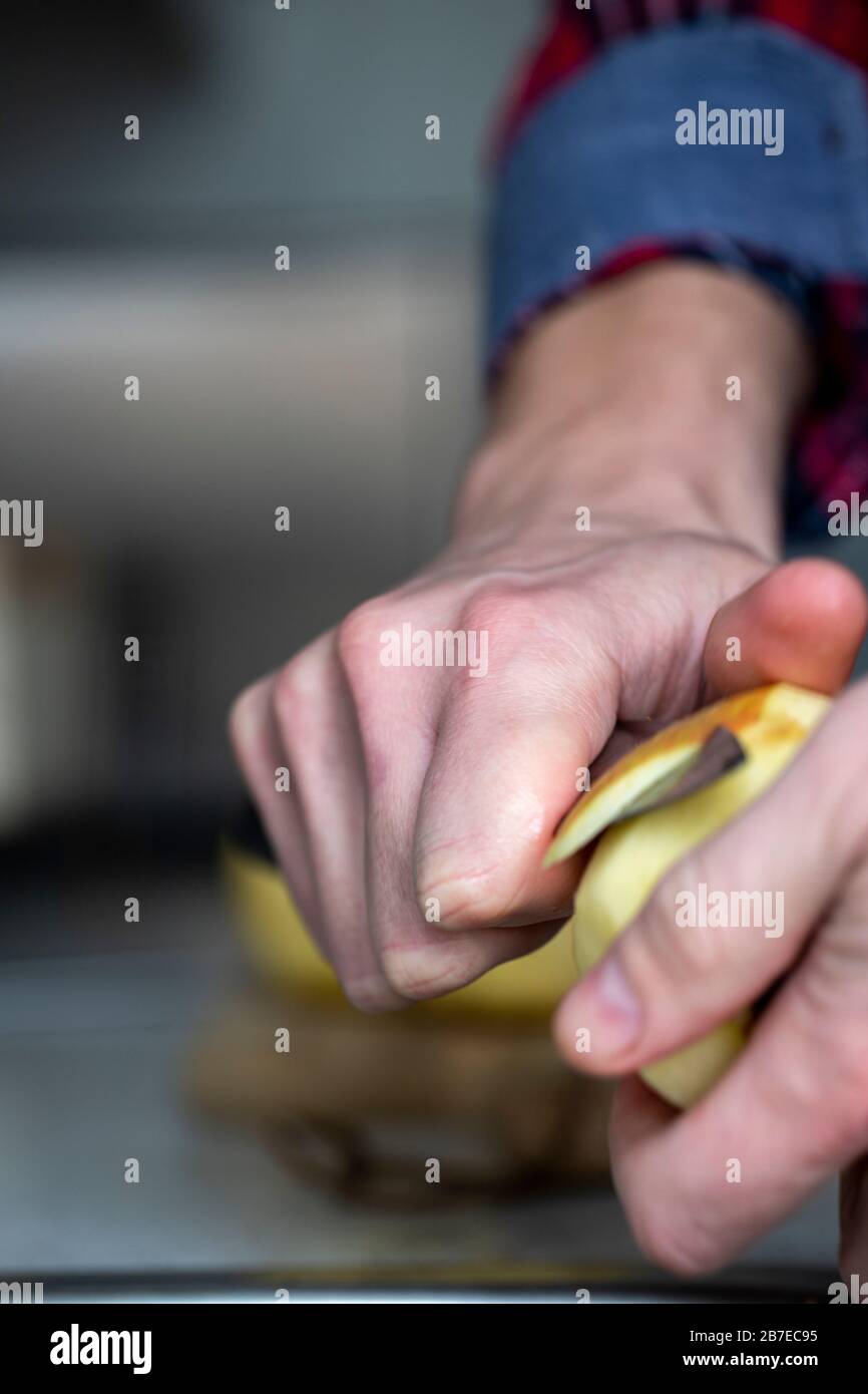 Peeling apples for apple pie hand visible. Stock Photo