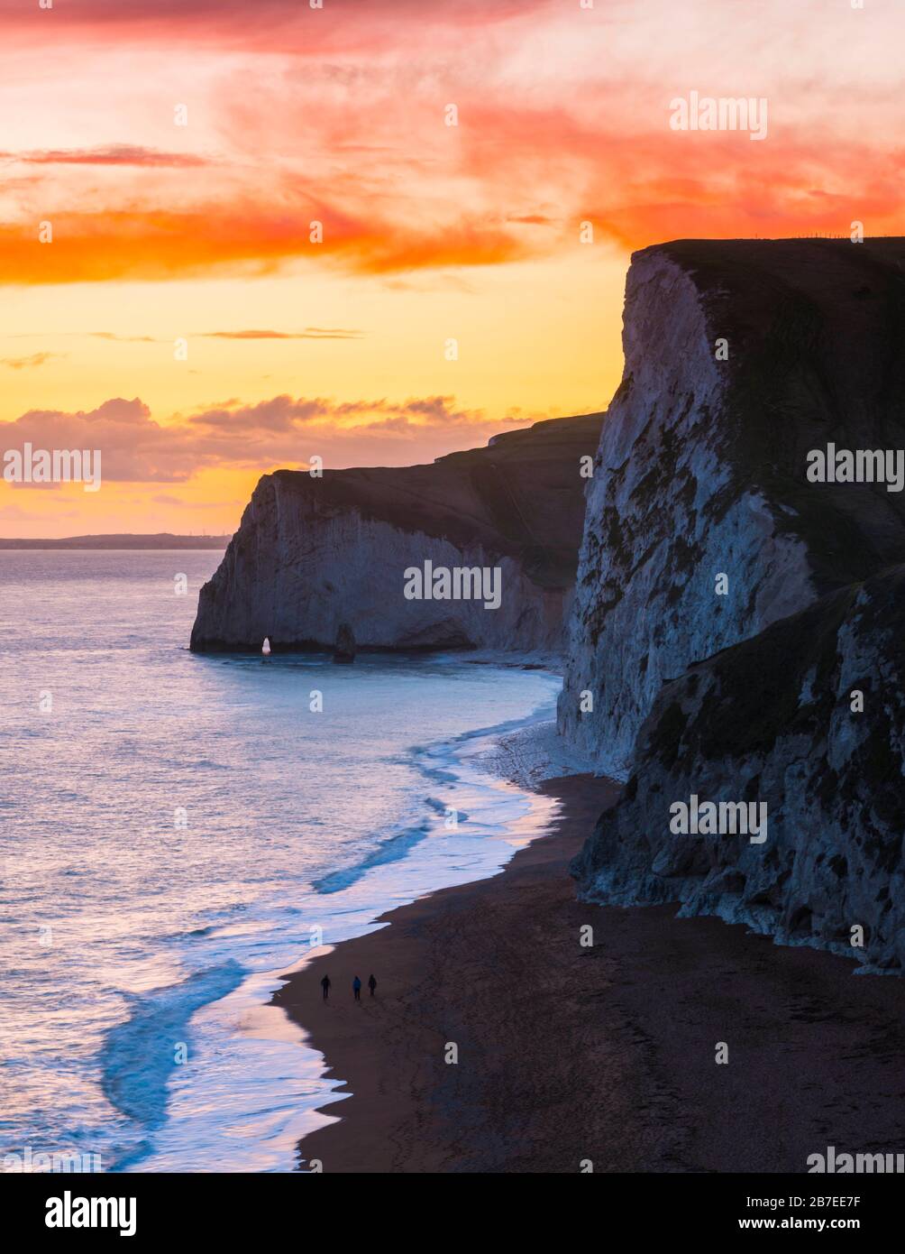 Durdle Door, Lulworth, Dorset, UK.  15th March 2020.  UK Weather.  A spectacular fiery sunset at Durdle Door on the Dorset Jurassic Coast near Lulworth looking towards Swyre Head and Bats Head as the cloud clears as high pressure builds in from the South West.  Picture Credit: Graham Hunt/Alamy Live News Stock Photo