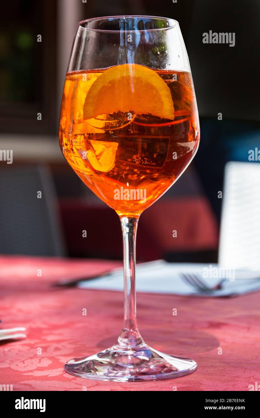 A glass with bright orange liquid, ice and a slice of orange, Spritz Aperol cocktail Stock Photo