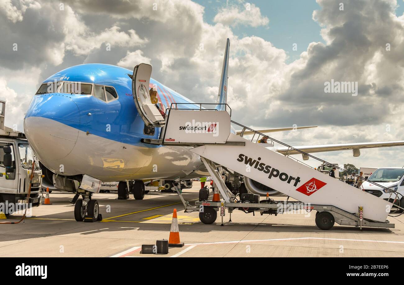 BRISTOL, ENGLAND - AUGUST 2019:  Passenger steps of handling company SWISSPORT connected to a TUI Boeing 737 holiday jet at Bristol airport. Stock Photo