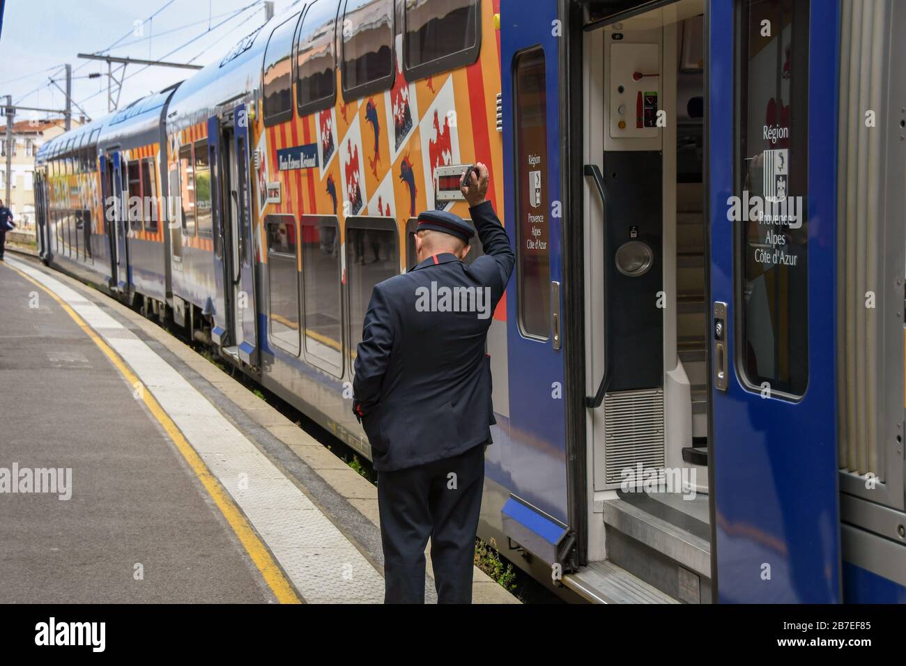 ST RAPHAEL, FRANCE - APRIL 2019: Rail guard signalling to the driver the train is ready for departure. Stock Photo