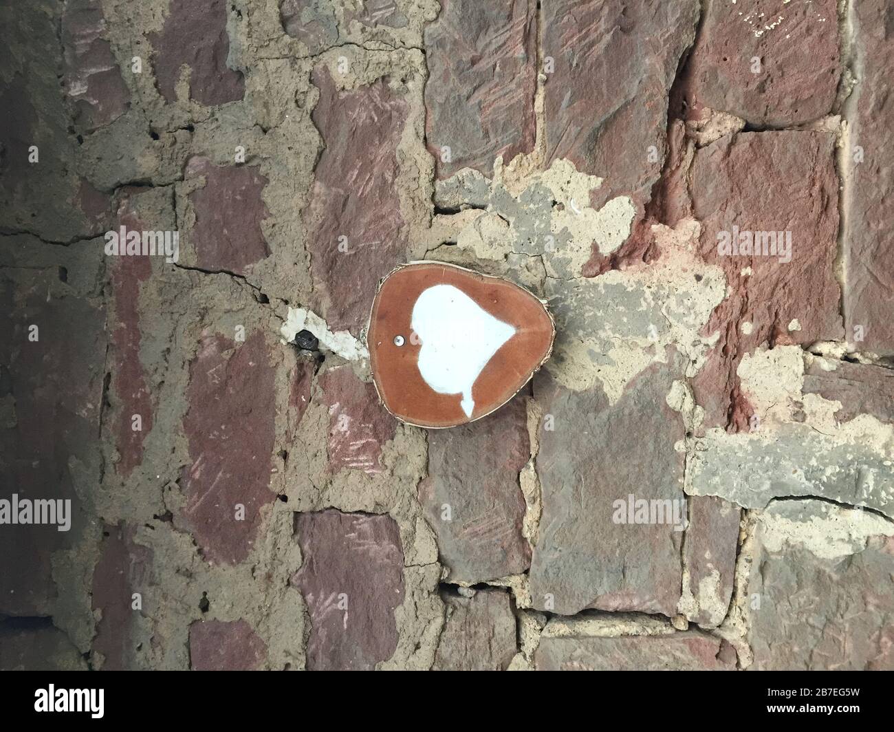Vertical shot of a drawing of a heart and an arrow attached to a wall Stock Photo