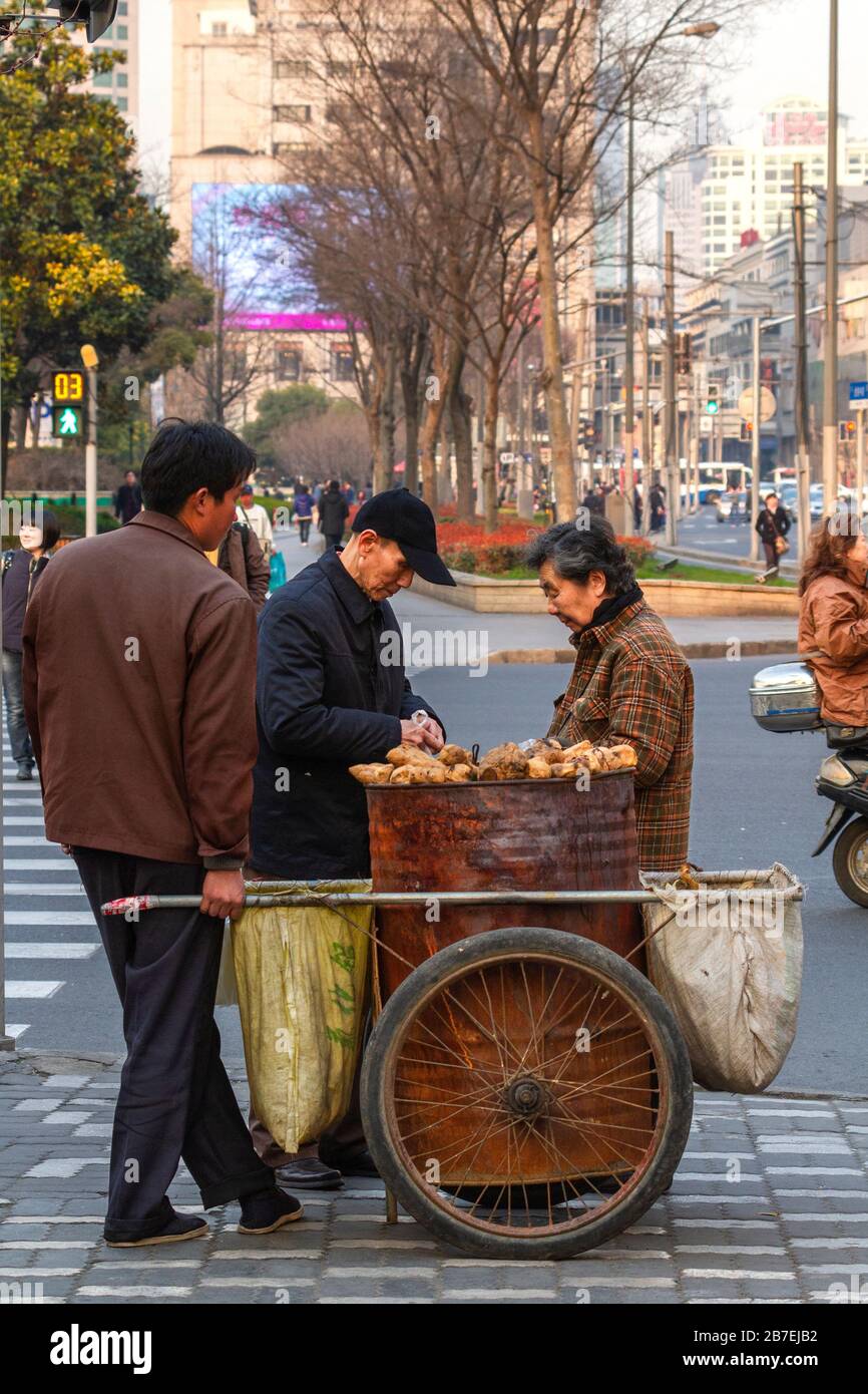 Streel life around Pu'an Lu and Jinling Lu, downtown Shanghai Puxi, China. Street vendor with customers. Stock Photo