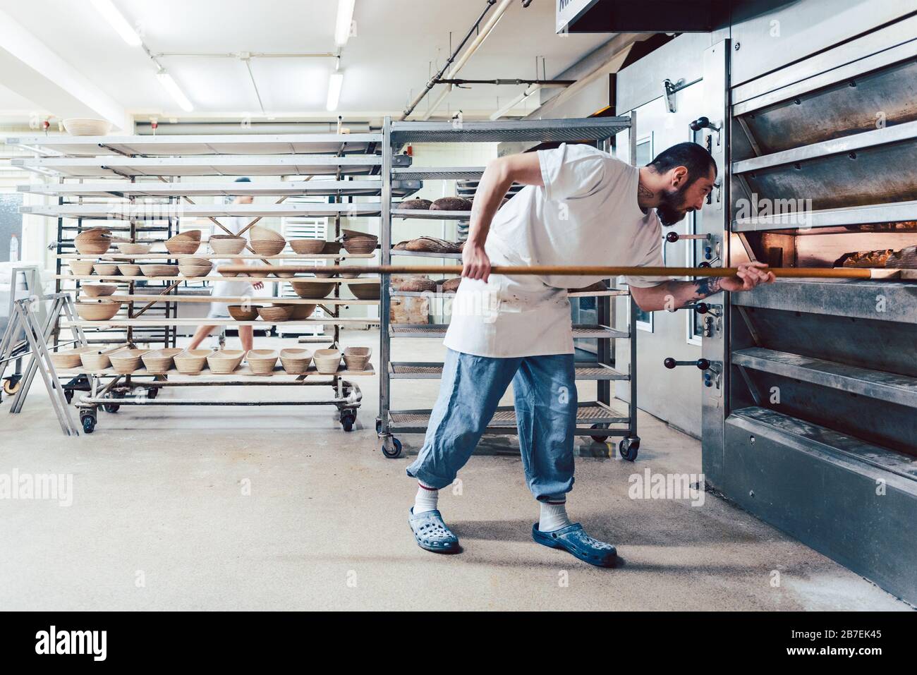 Baker checking bread in the baker oven Stock Photo Alamy