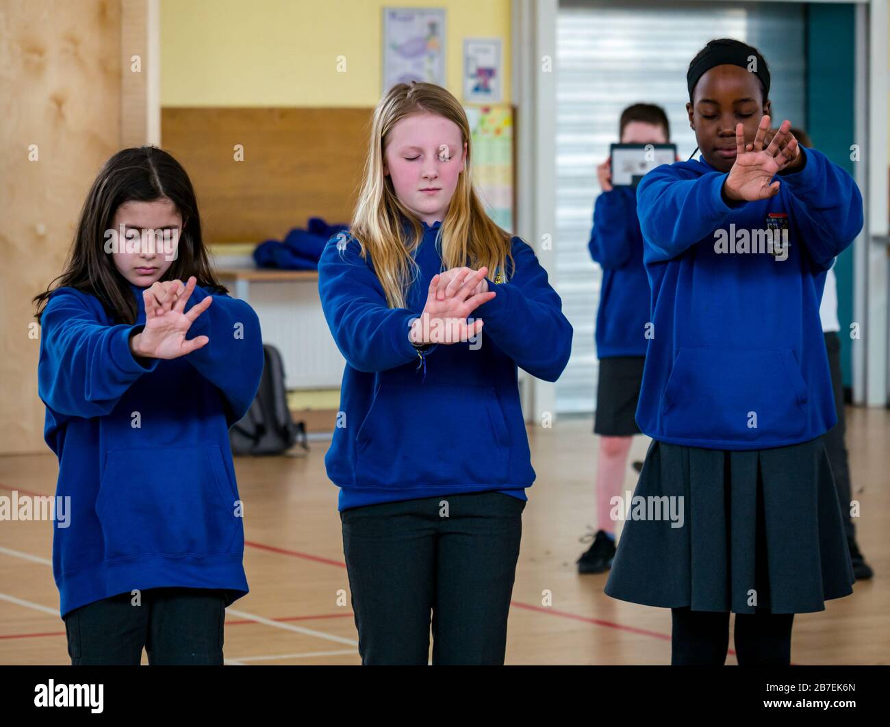 Female school pupils doing meditation exercise, Davidsons Mains primary school, Edinburgh, Scotland, UK Stock Photo