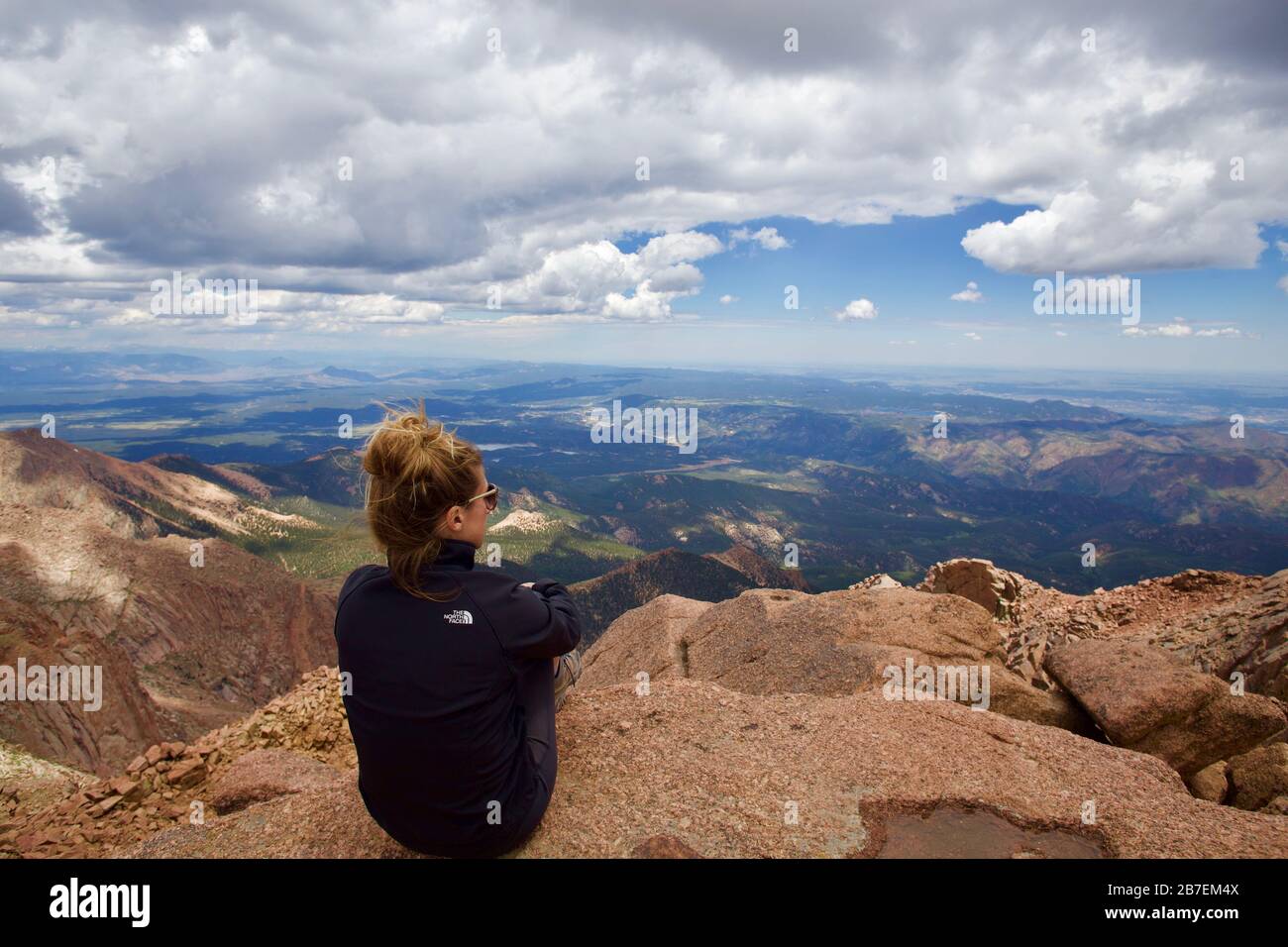 Woman sitting rocky peak hi-res stock photography and images - Alamy