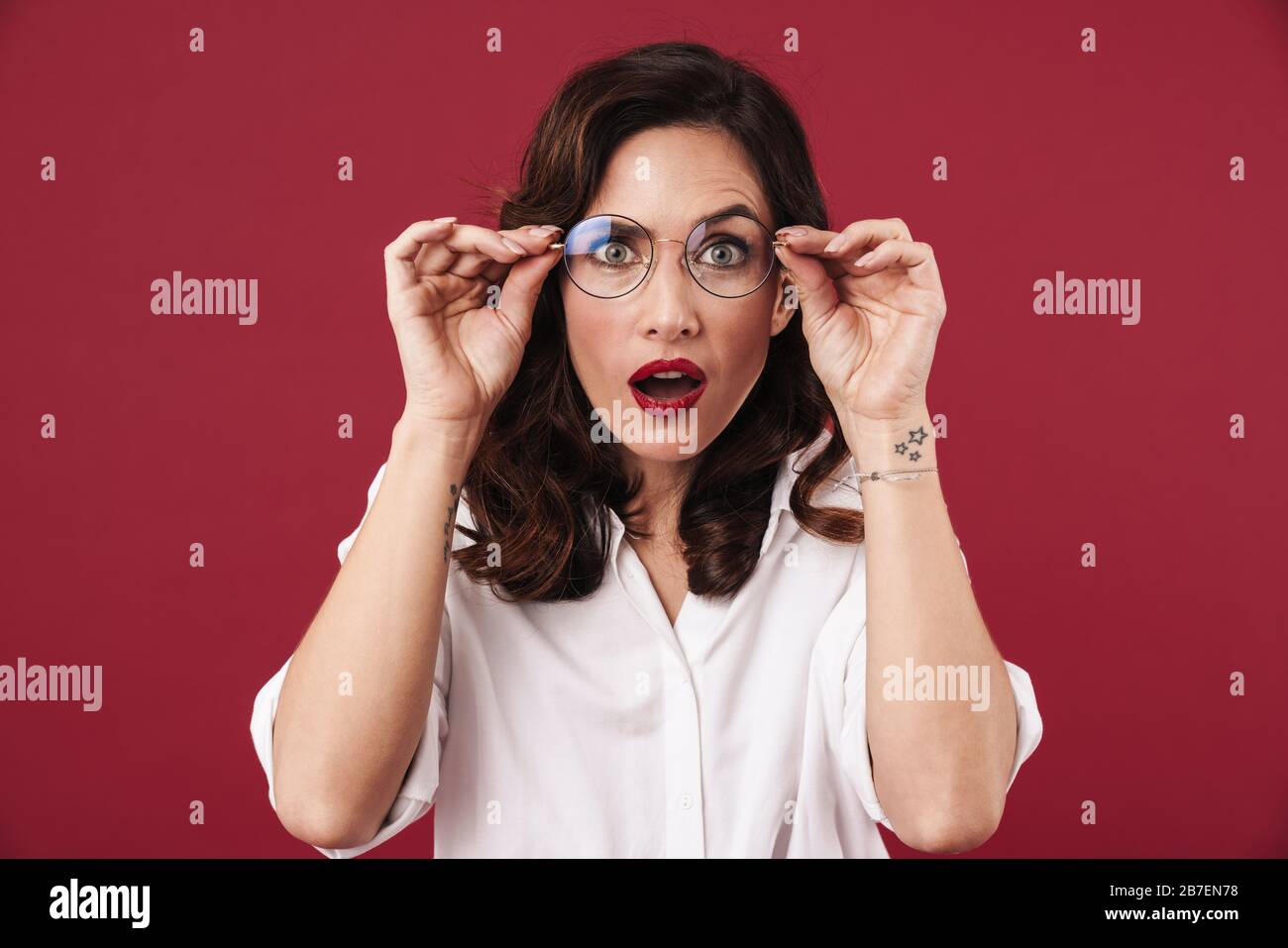 Photo of a shocked surprised young pretty woman posing isolated over ...