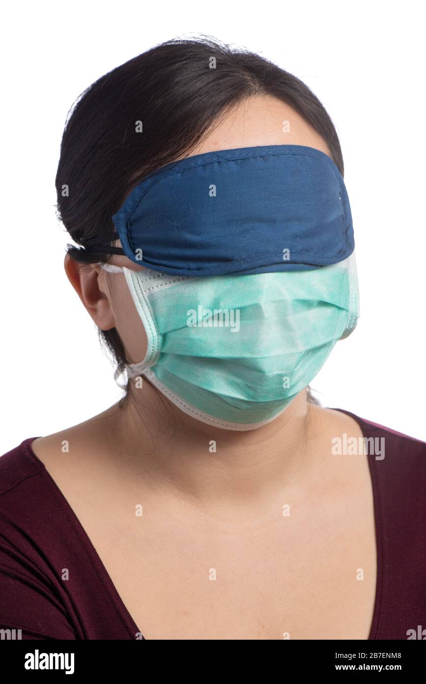 young asiatic woman wearing a green protection mask and a sleeping mask on a white background Stock Photo