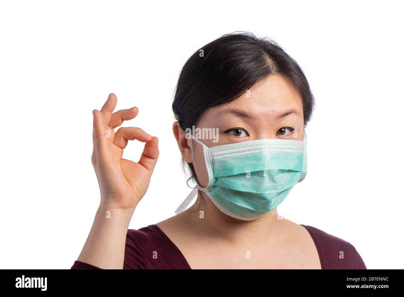 young asiatic woman wearing a green protection mask with medical gloves making ok sign on a white background Stock Photo