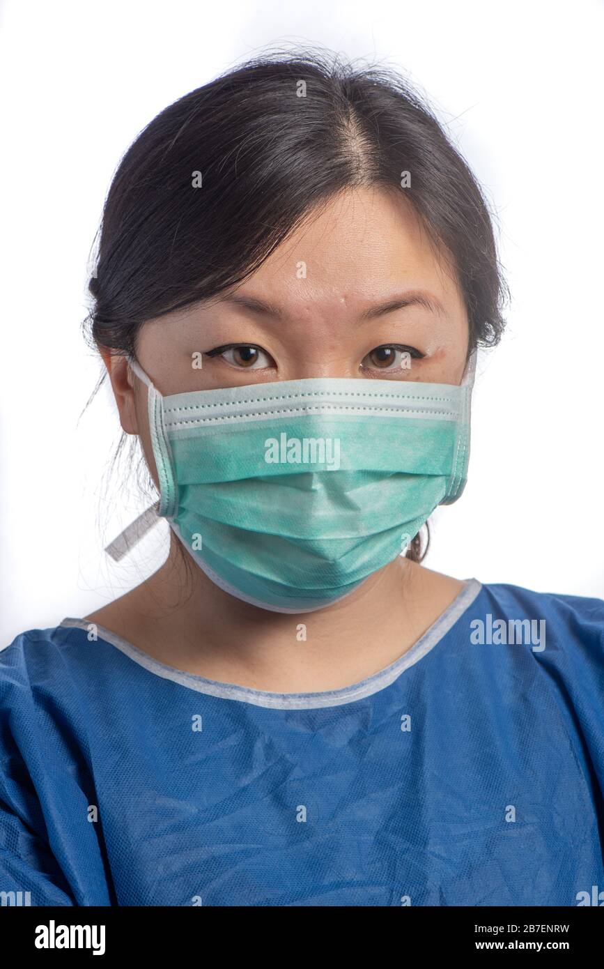 young asiatic physician woman wearing a green protection mask with medical gloves arms cross on a white background Stock Photo